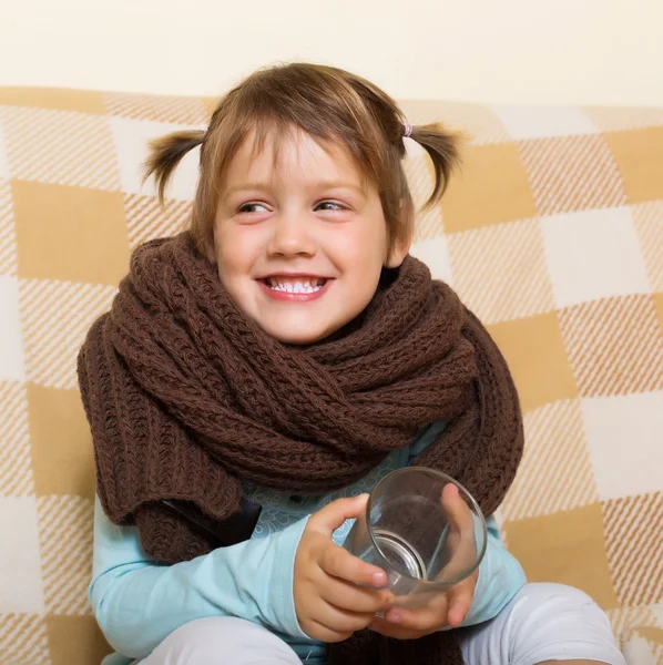 Gelukkig babymeisje in warme sjaal met glas — Stockfoto