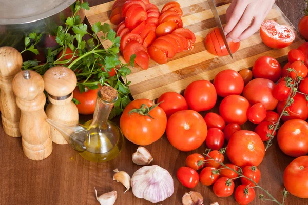 Mãos cortando tomates — Fotografia de Stock