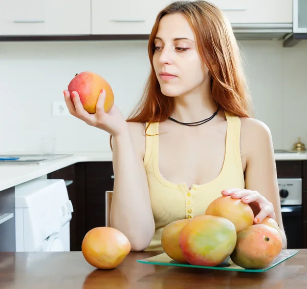 Langharige vrouw kijken naar mango — Stockfoto