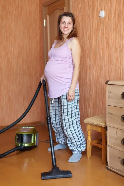 Беременная женщина убирает дома — стоковое фото