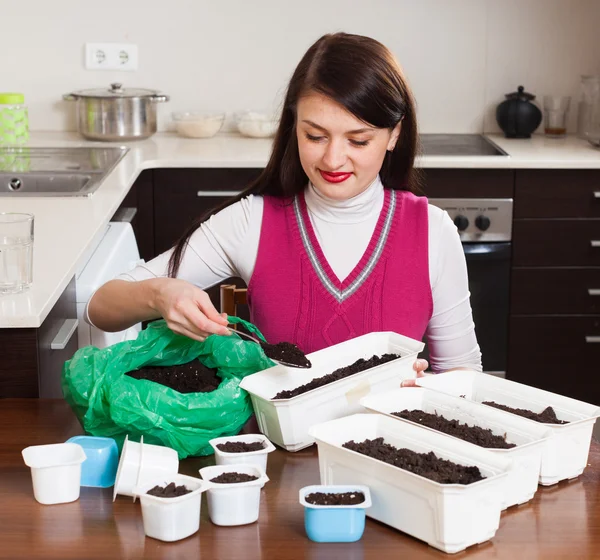 Brunette woman making ground in pots — Stock Photo, Image
