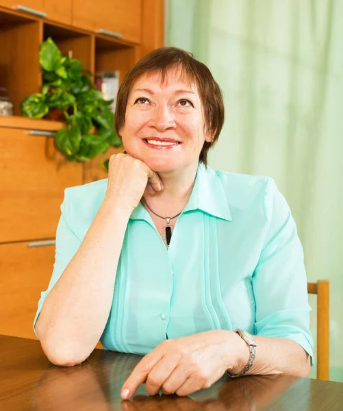 Mujer madura feliz sentado y sonriendo — Foto de Stock