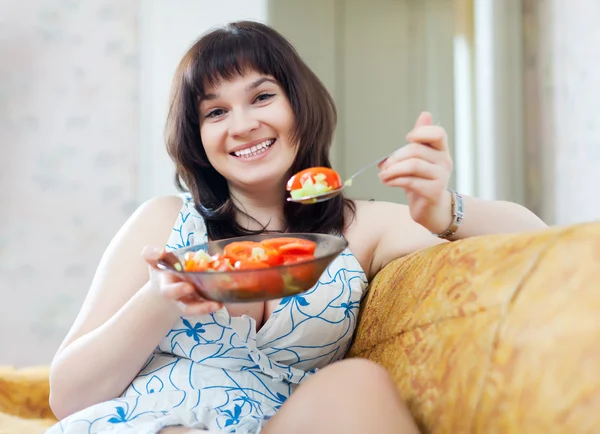 Happy ordinary woman eats vegetables — Stock Photo, Image