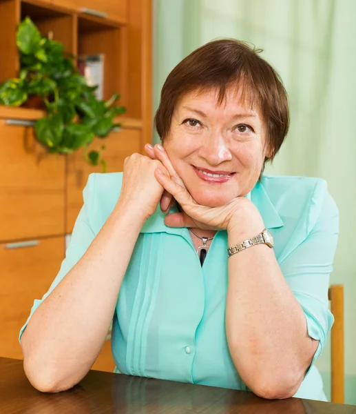 Reife Frau am Tisch — Stockfoto