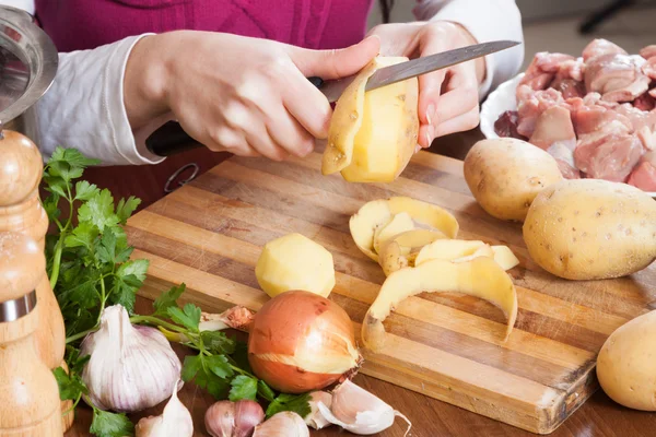 Reiniging van aardappelen aan tafel — Stockfoto