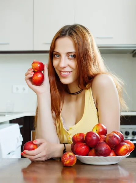 Mujer con nectarinas en la cocina — Foto de Stock
