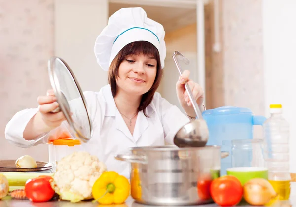 Frau in Haube kocht mit Schöpfkelle — Stockfoto