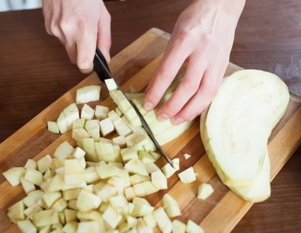 Vrouwelijke handen snijden aubergine — Stockfoto