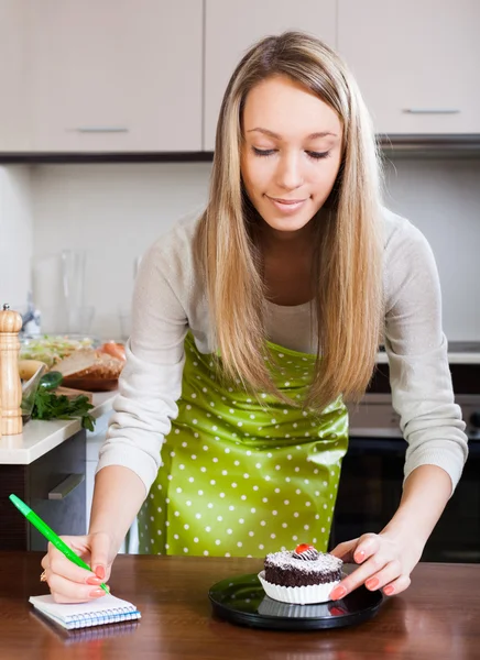 Girl in apron weighing cakes — Stock Photo, Image