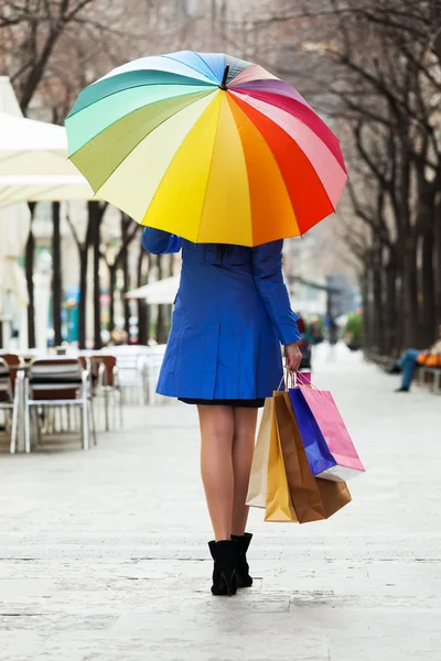 Женщина с покупками и зонтиком — стоковое фото