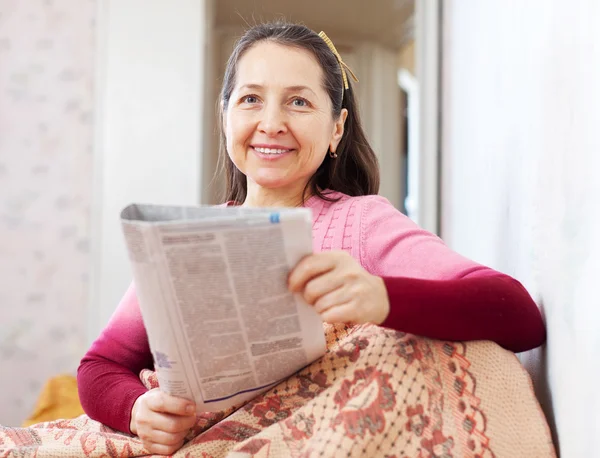 Šťastný zralá žena čte noviny — Stock fotografie