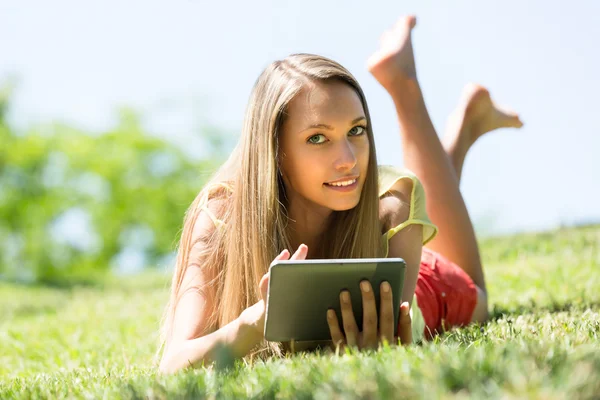 Meisje ontspannen buiten met Tablet PC — Stockfoto