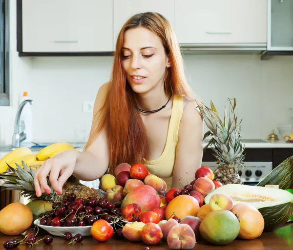 Kvinna med högen av mogna frukter — Stockfoto