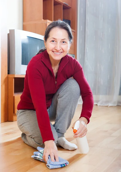 Donna matura lucidatura pavimento in parquet — Foto Stock