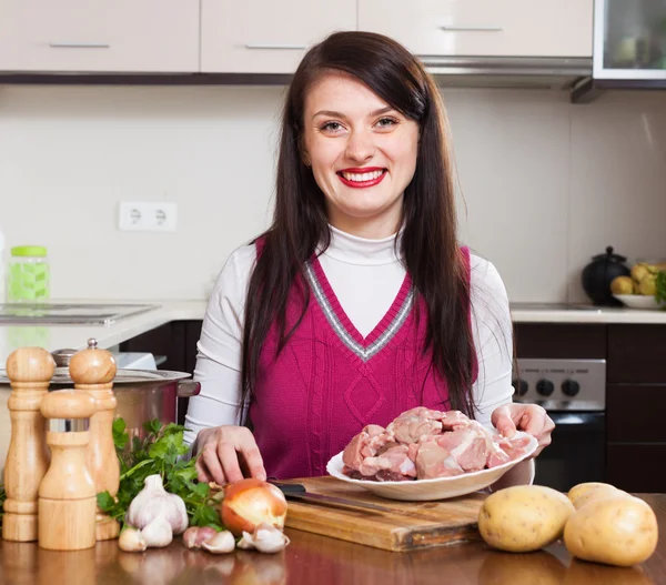 Donna felice cucina con carne — Foto Stock