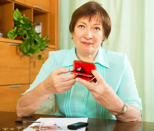 Frau schaut besorgt auf Geld — Stockfoto