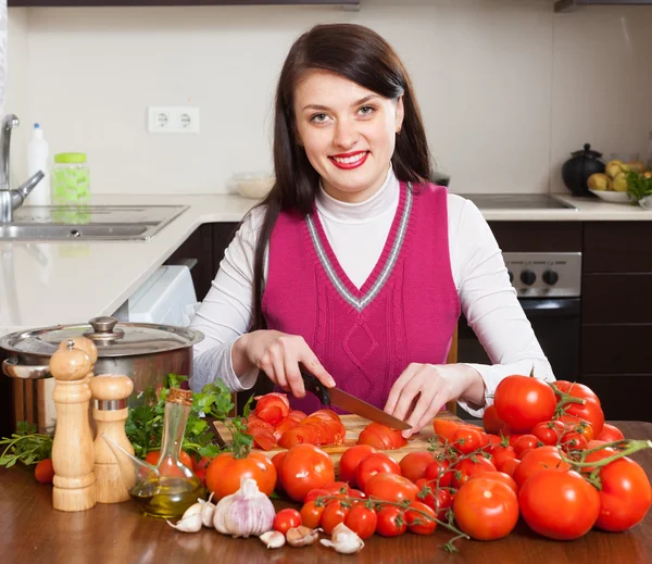 Brunette woman slicing tomatoes — Stock Photo, Image