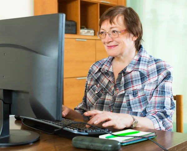 Elderly woman working with computer — Stock Photo, Image