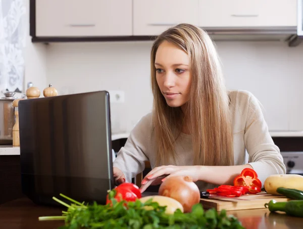 Mujer usando portátil en la cocina —  Fotos de Stock