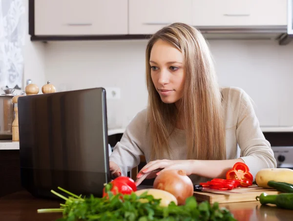 Vrouw met laptop in de keuken — Stockfoto