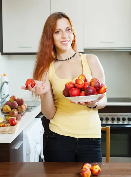 Long-haired girl with nectarines — Stock Photo, Image