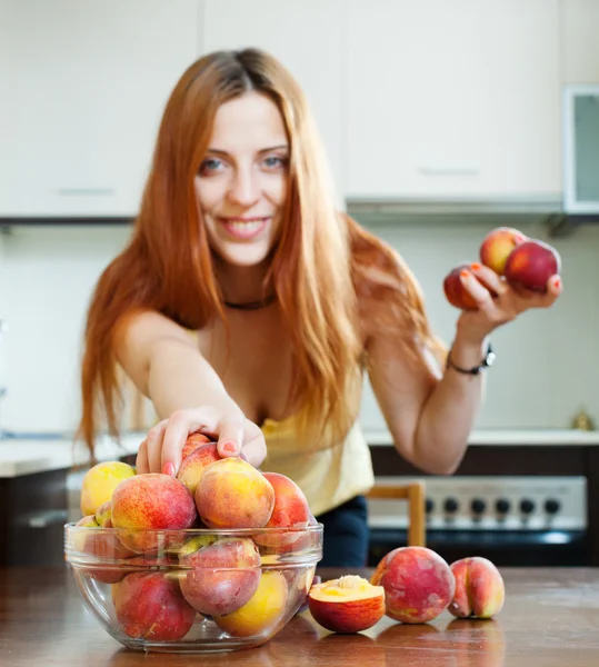 Домохозяйка берет персики — стоковое фото
