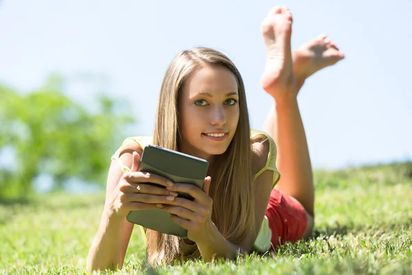 Meisje ontspannen buiten met Tablet PC — Stockfoto