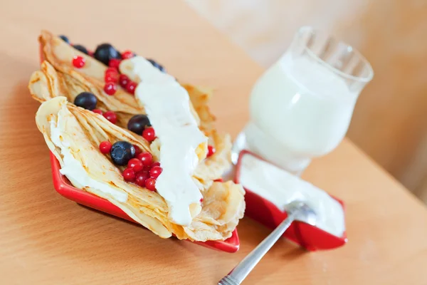 Pancakes with berries and glass of milk — Stock Photo, Image