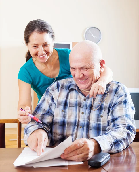 Joyful mature couple reading financial documents — Stock Photo, Image