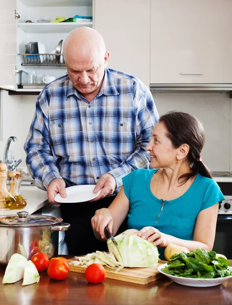 Uomo anziano e donna matura cucina in cucina — Foto Stock