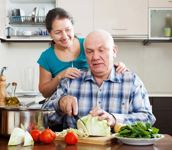 Mature couple cooking food together — Stock Photo, Image