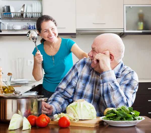 Jogando madura casal cozinhar alimentos — Fotografia de Stock