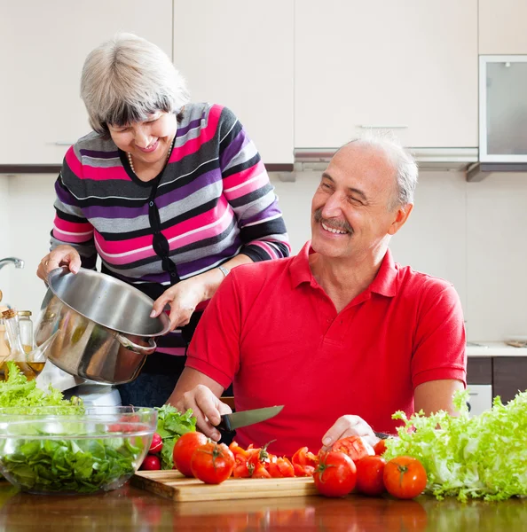 Mature couple cooking with tomatoes — Stock Photo, Image