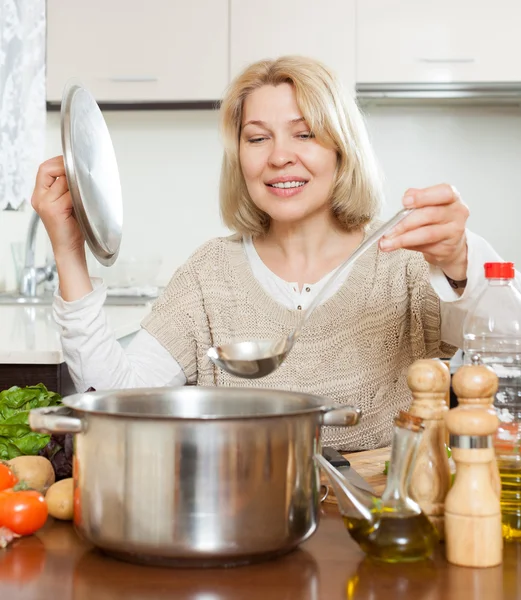 Donna sorridente zuppa di cottura — Foto Stock