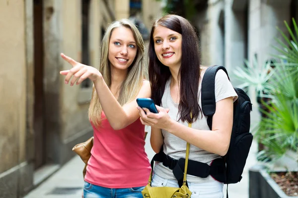 Twee meisjes met behulp van smartphone voor vinden een manier — Stockfoto