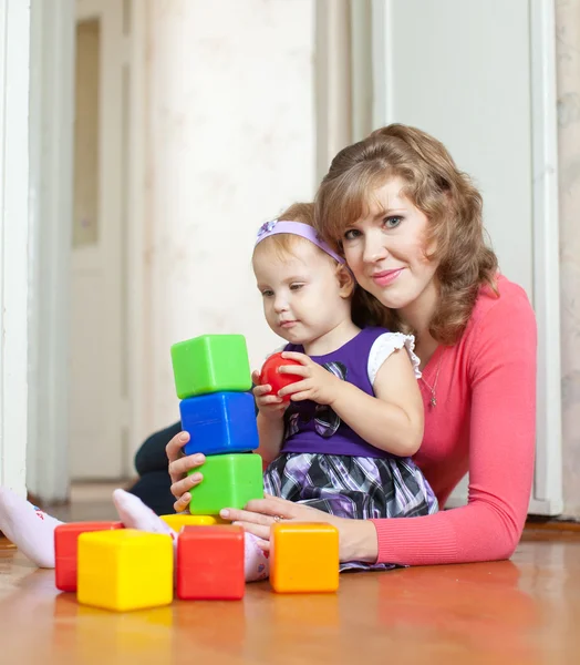 Moeder en baby meisje speelt met blokken in huis — Stockfoto