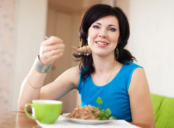 Pretty woman eats buckwheat — Stock Photo, Image