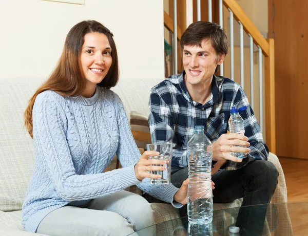 Uomo felice e giovane donna bere acqua — Foto Stock