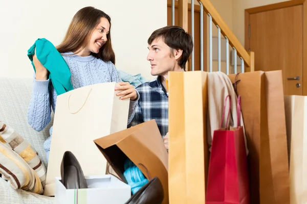 Happy guy and girl looking their  purchases — Stock Photo, Image