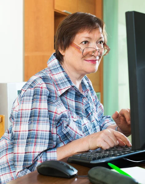 Elderly woman working with computer — Stock Photo, Image