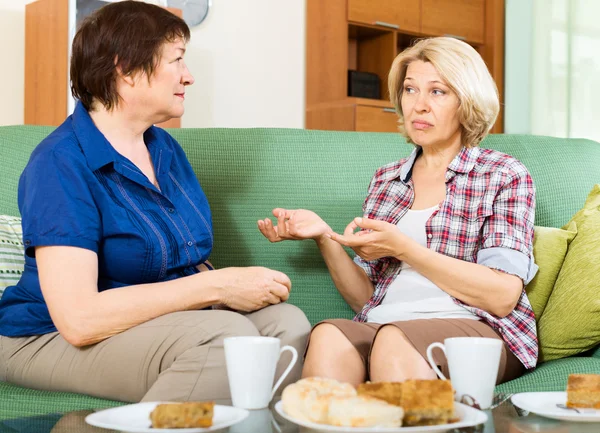 Two sad mature women chating on couch — Stock Photo, Image
