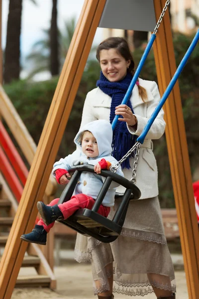Woman with  toddler on swings — Stock Photo, Image