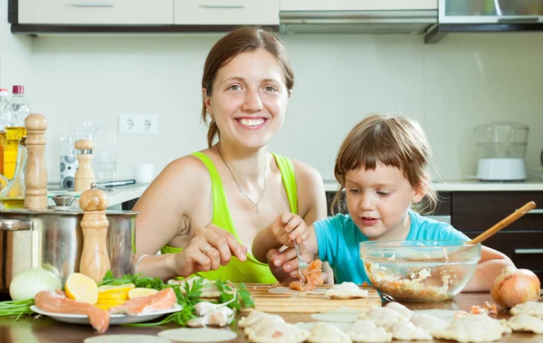 Ama de casa con hija hace albóndigas de salmón — Foto de Stock