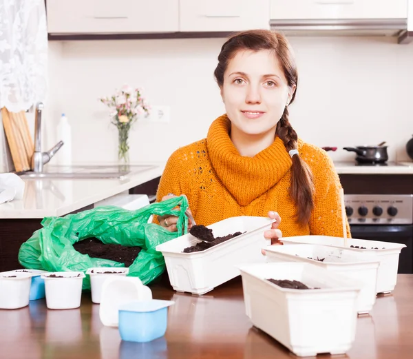 Girl making ground in pots for seedlings — Stock Photo, Image