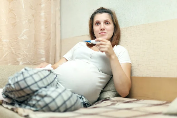 Hamile kadın termometre ile oturuyordu — Stok fotoğraf