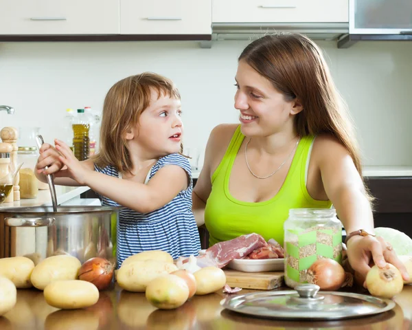 Boldog anya gyermekével leves főzés — Stock Fotó