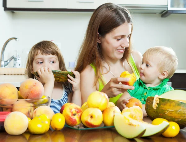 Mulher com filhos comendo frutas — Fotografia de Stock