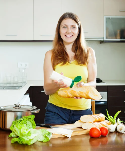 Happy girl cooking sandwiches with mayonnaise — Stock Photo, Image