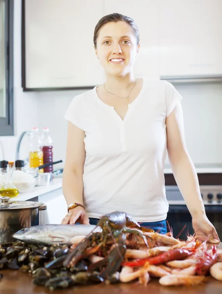 Glad kvinna med skaldjur i kök — Stockfoto