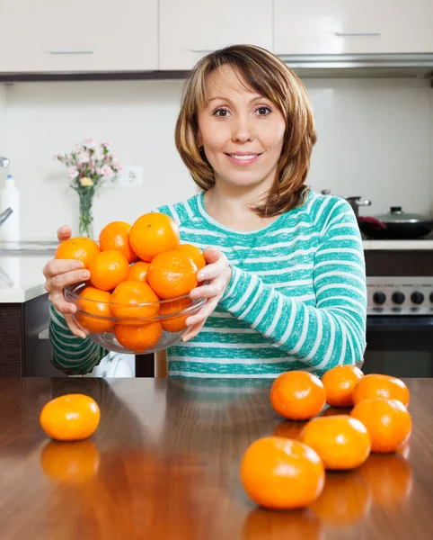 Chica feliz sosteniendo montón de mandarinas — Foto de Stock